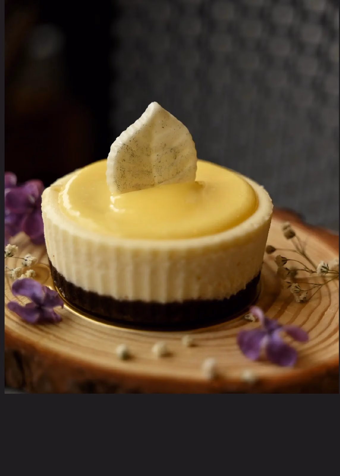 A lemon cheesecake with a white chocolate leaf and spring flowers