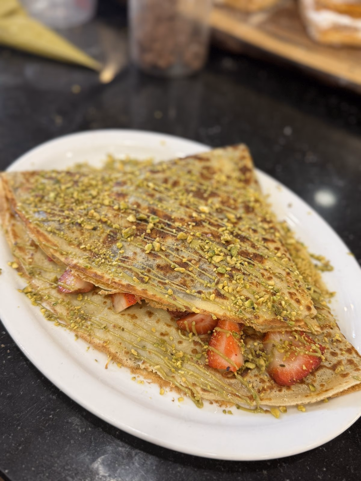 A pistachio crêpe filled with strawberries